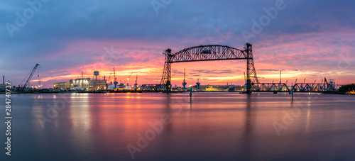 Vertical lift bridge for railroad over the Elizabeth River on the border of Norfolk and Chesapeake Virginia against a beautiful red, purple, pink, and blue sunset photo