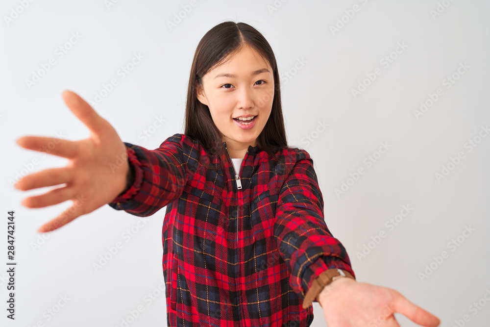 Young chinese woman wearing casual jacket standing over isolated white background looking at the camera smiling with open arms for hug. Cheerful expression embracing happiness. Young chinese woman wearing casual jacket standing over isolated white background looking at the camera smiling with open arms for hug. Cheerful expression embracing happiness.