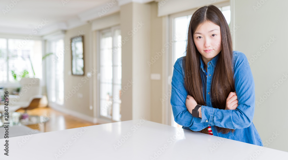 Young beautiful asian woman with long hair wearing denim jacket shaking and freezing for winter cold with sad and shock expression on face Young beautiful asian woman with long hair wearing denim jacket shaking and freezing for winter cold with sad and shock expression on face