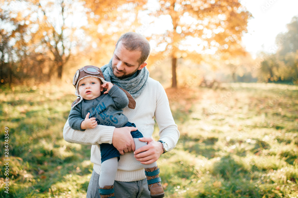 Fototapeta premium Happy father posing with his stylish child in autumn park