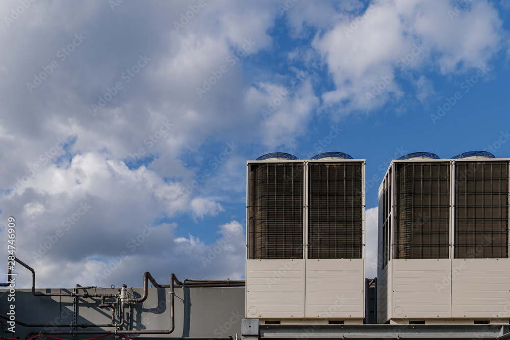 Heating and Cooling System of air Air Conditioning System set up on rooftop of building against blue sky.