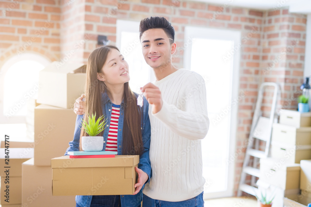 Young asian couple holding keys of new house, smiling happy and excited moving to a new apartment Young asian couple holding keys of new house, smiling happy and excited moving to a new apartment