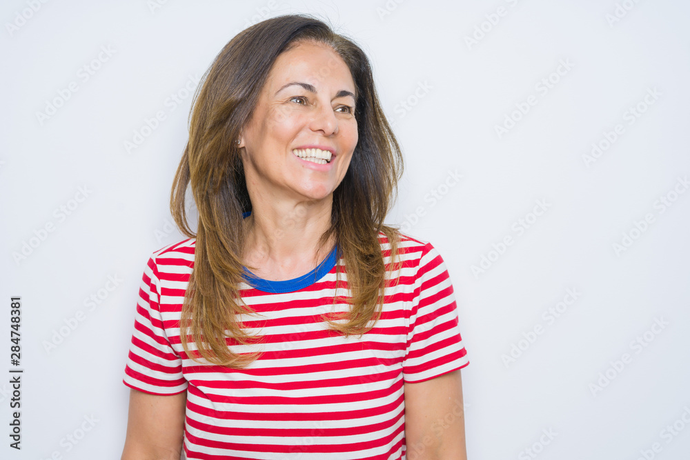 Middle age senior woman standing over white isolated background looking away to side with smile on face, natural expression. Laughing confident. Middle age senior woman standing over white isolated background looking away to side with smile on face, natural expression. Laughing confident.
