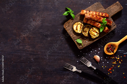 grilled sausages and eggplant on a wooden cutting board Top view