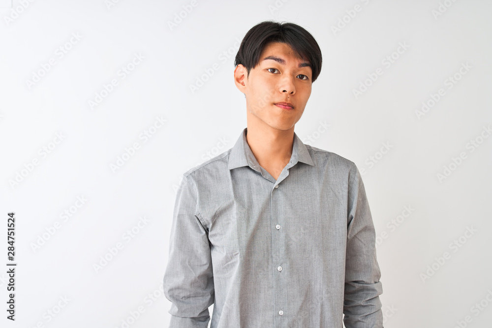 Chinese businessman wearing elegant shirt standing over isolated white background with serious expression on face. Simple and natural looking at the camera. Chinese businessman wearing elegant shirt standing over isolated white background with serious expression on face. Simple and natural looking at the camera.