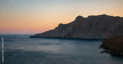 Fototapeta Naklejka Na Ścianę i Meble -  Tripiti beach east Crete on sunset. Trafoulas mountain near to Lendas, Crete Greece. Beautiful landscape sea and mountains on sunset.