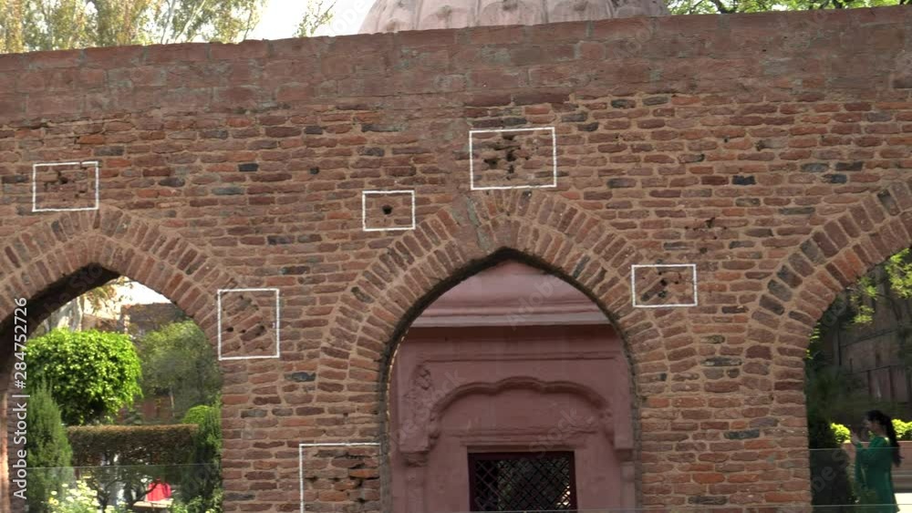 a close pan of bullet marks on a wall at jallianwala bagh in amritsar, india a close pan of bullet marks on a wall at jallianwala bagh in amritsar, india