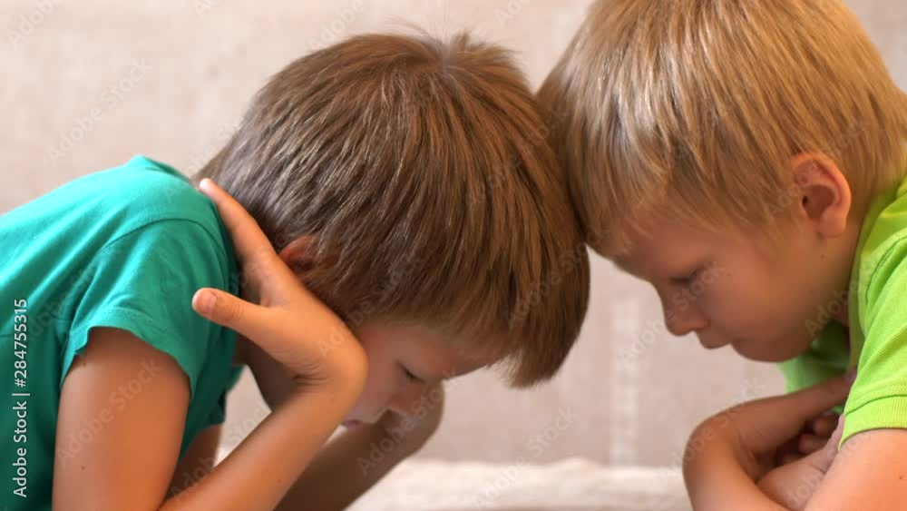 Happy calm children are playing with tablet. boys are happy together on vacation at their parents' house. Friendly joint preparation for school.