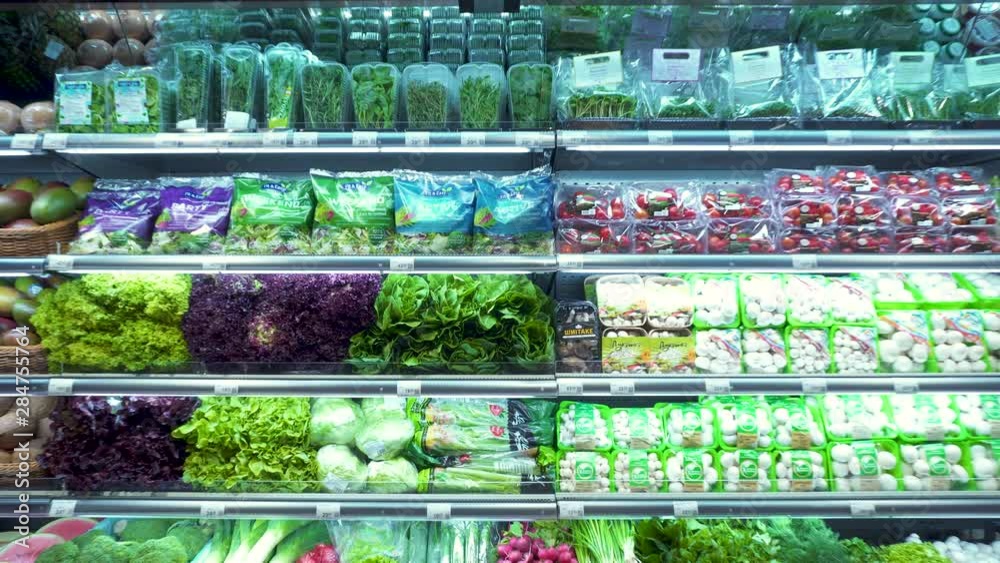 Different vegetables and fresh seasoning on a counter in a supermarket