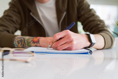 Close up of man hands writing on notebook, working taking notes
