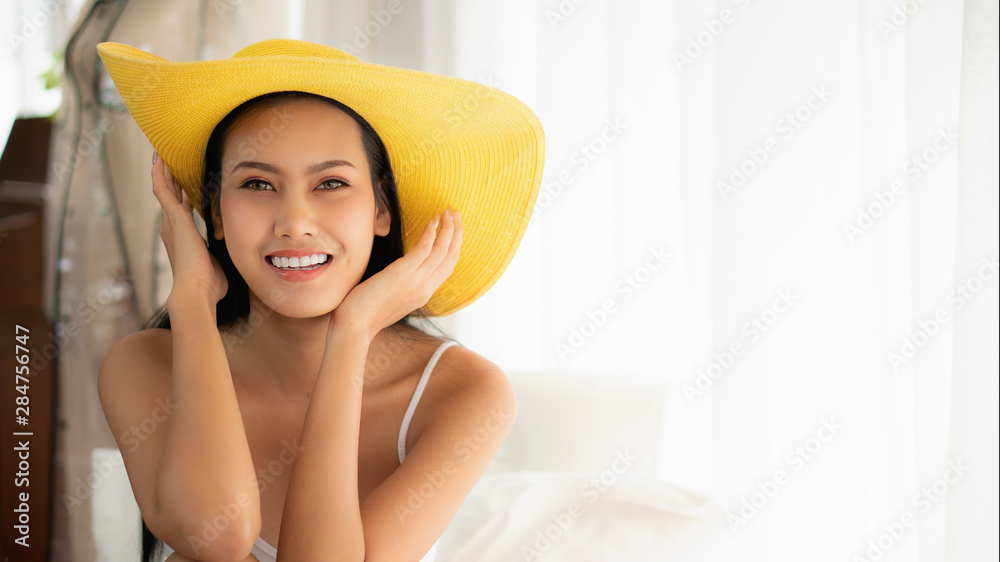 asian beautiful young happy woman in casual dress with yellow hat in white room with smile asian beautiful young happy woman in casual dress with yellow hat in white room with smile