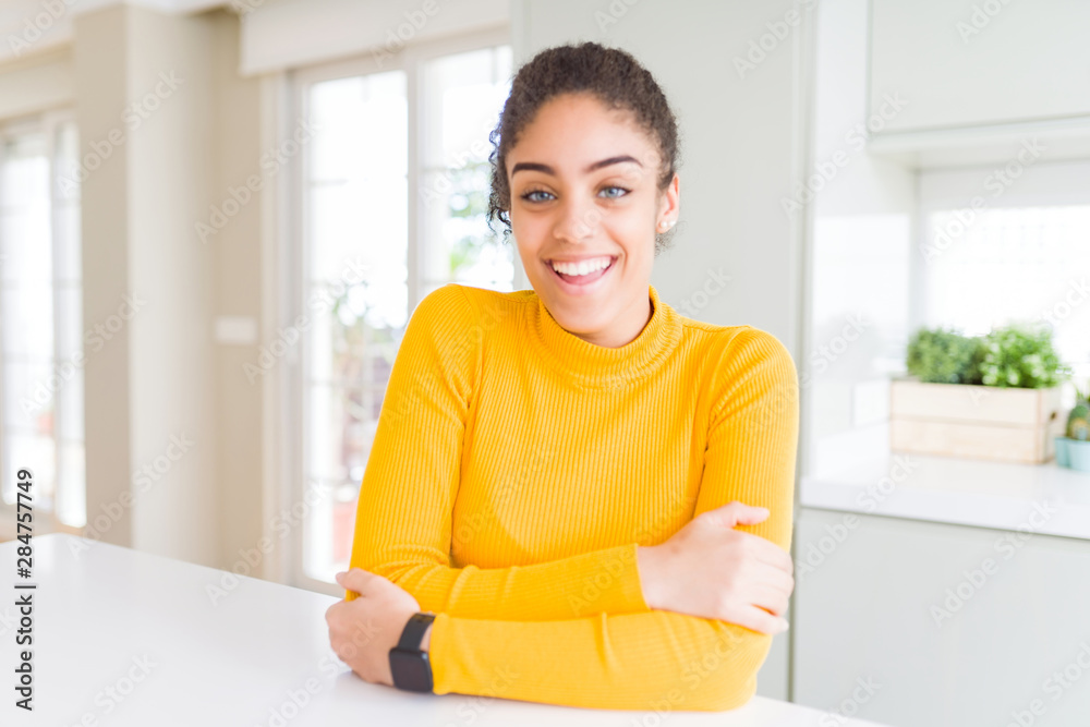 Beautiful young african american woman with afro hair happy face smiling with crossed arms looking at the camera. Positive person. Beautiful young african american woman with afro hair happy face smiling with crossed arms looking at the camera. Positive person.
