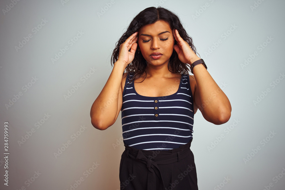 Transsexual transgender woman wearing striped t-shirt over isolated white background with hand on headache because stress. Suffering migraine. Transsexual transgender woman wearing striped t-shirt over isolated white background with hand on headache because stress. Suffering migraine.