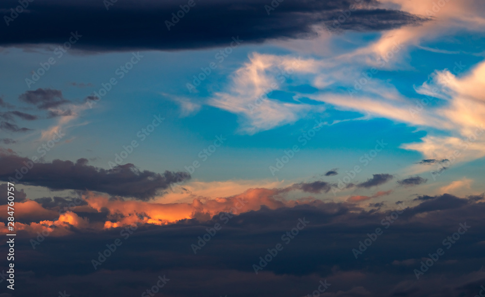 Beautiful sunset sky. Orange, blue, and white sky. Colorful sunrise. Art picture of sky at sunrise. Sunrise and clouds for inspiration background. Nature background. Peaceful and tranquil concept.