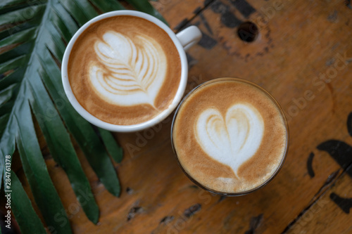 cup of coffee with cream on wooden background