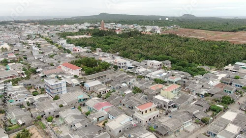 At one exotic island in Vietnam, flying over a village with many traditional Vietnamese houses and lots of lush patches. photo