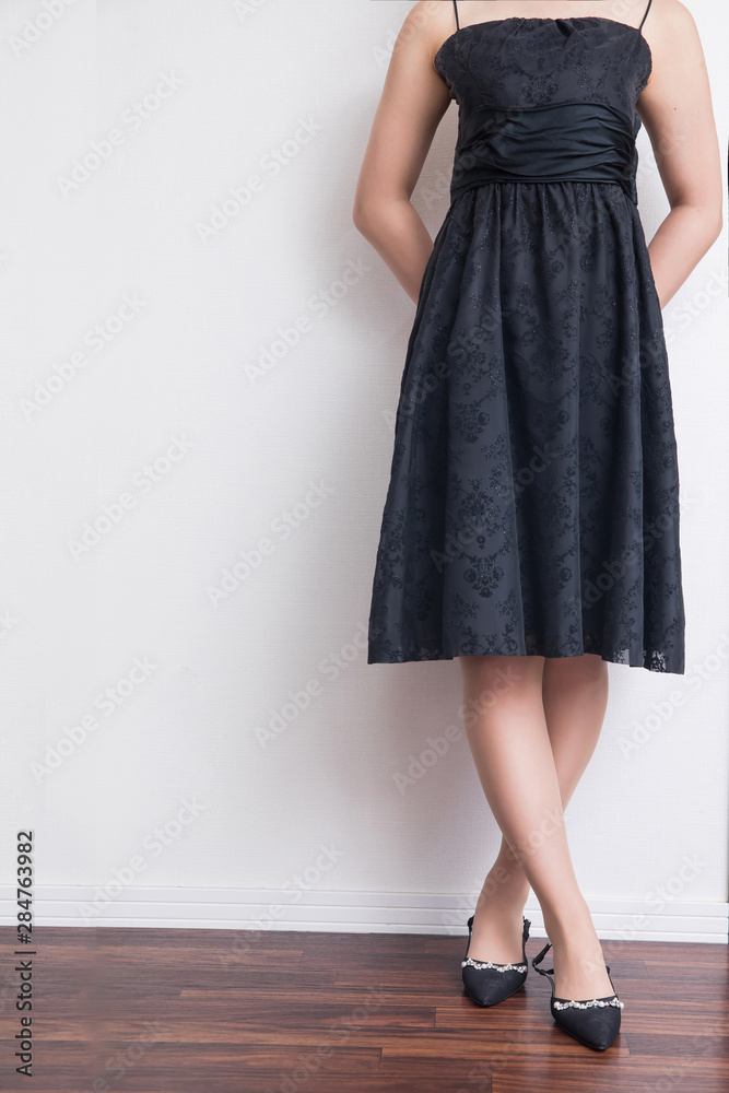白背景に黒いAラインのワンピースを着ている女性美脚パーティー披露宴
