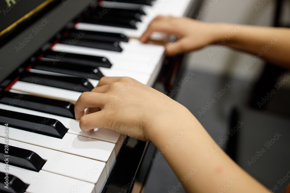 Two Small Childent's Hands Playing The Piano