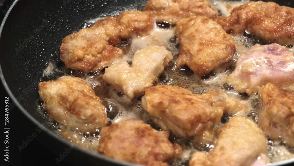 Close up on chicken nuggets cooking in hot oil in a frying pan, 4K Close up on chicken nuggets cooking in hot oil in a frying pan, 4K