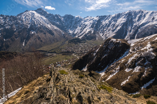 Fototapeta Naklejka Na Ścianę i Meble -  View from the mountain to the Georgian villages of Gergeti and Stepantsminda