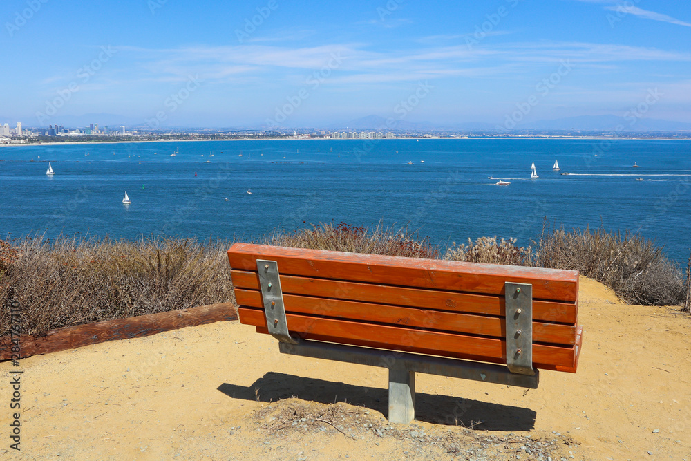 An empty bench sits overlooking San Diego bay on the Bayside Trail at Cabrillo National Monument in Point Loma, California. An empty bench sits overlooking San Diego bay on the Bayside Trail at Cabrillo National Monument in Point Loma, California.