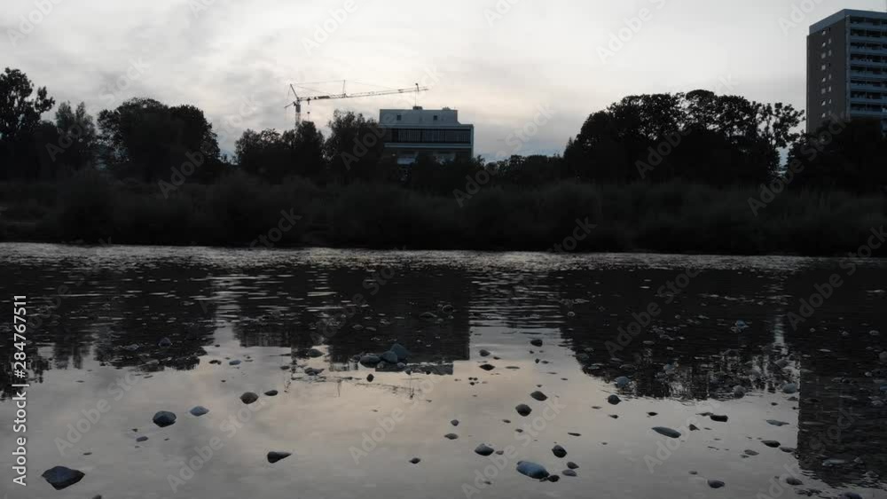 Calm river shoot with flowing water and rocs from a low angle in the afternoon at 4k 24fps