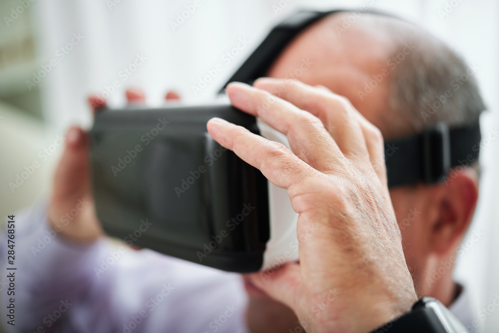 Close-up image of man putting on his new virtual reality glasses to play video game or enjoy movie