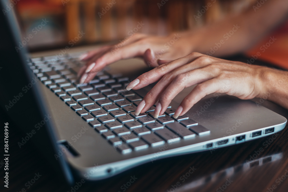 Close-up shot of female hands typing on laptop keyboard Close-up shot of female hands typing on laptop keyboard