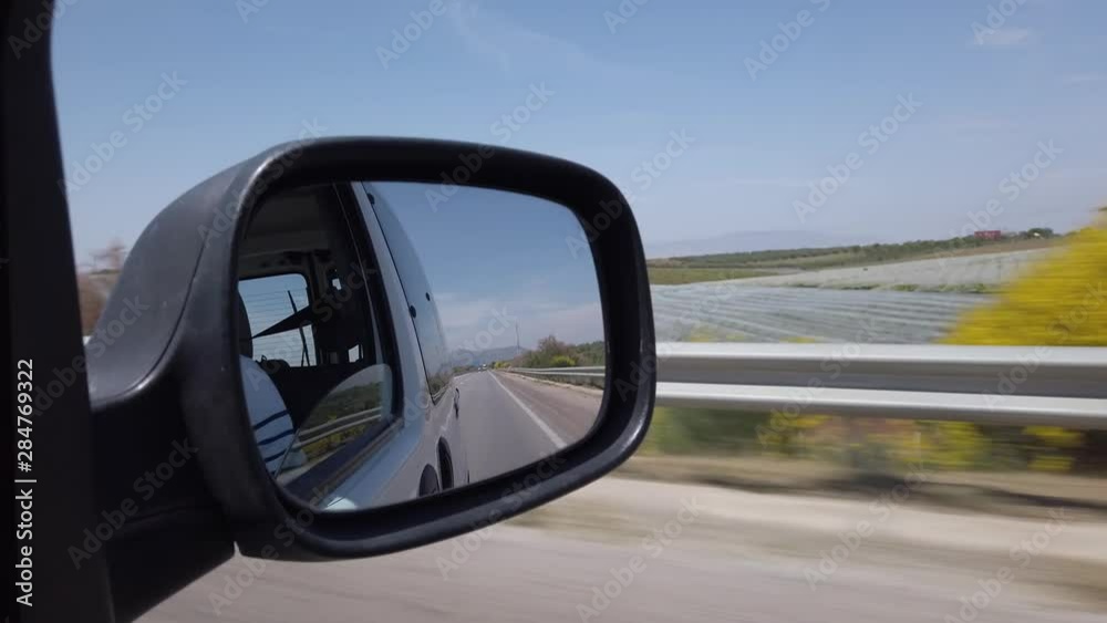 View through the side mirror of the landscape that passes between Fes and Meknes on the highway in Morocco. View through the side mirror of the landscape that passes between Fes and Meknes on the highway in Morocco.