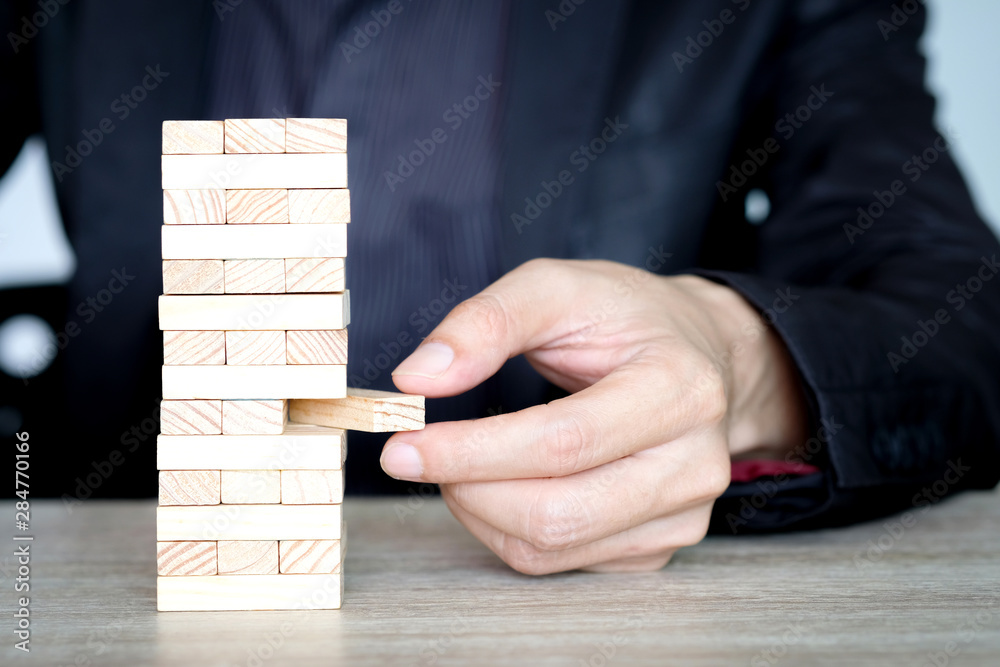 Steps of success for business or investment. Business man is arranging wood block to increase high, Business concept , Investment concept of successful. Steps of success for business or investment. Business man is arranging wood block to increase high, Business concept , Investment concept of successful.