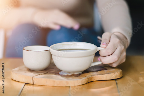 Young woman holding a cup of hot coffee in nature view