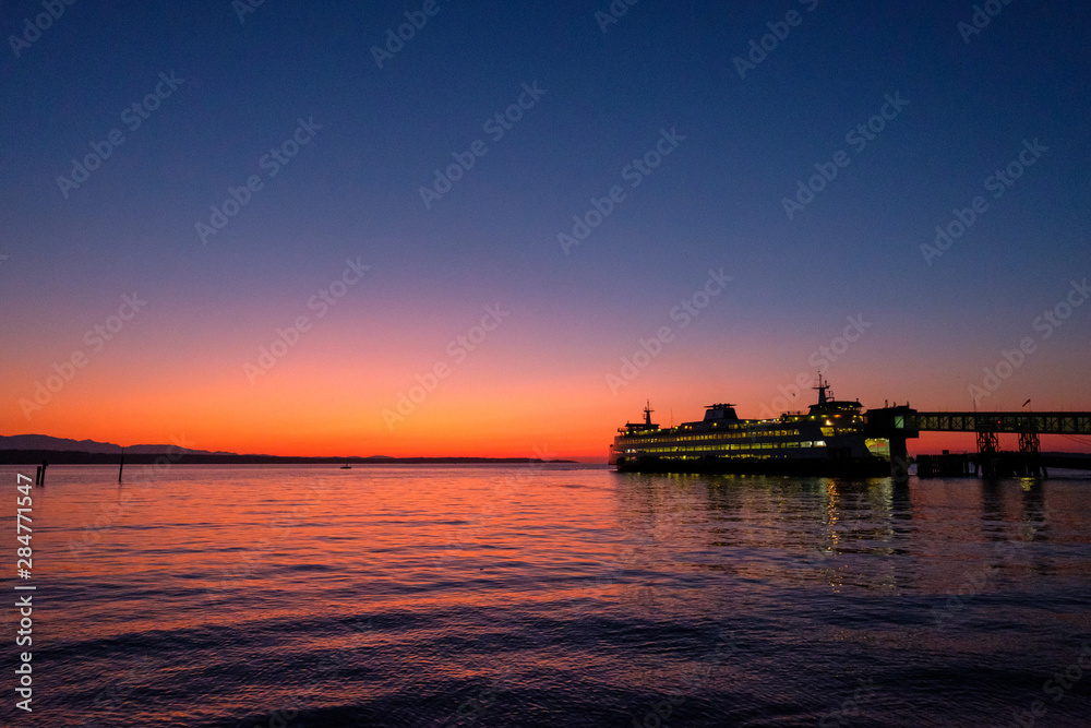 A long exposure at sunset of a beach and water and a ferry dock