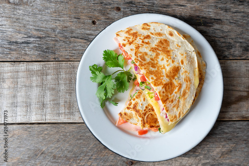 Mexican quesadillas with sliced ham also called "sincronizadas" on wooden background