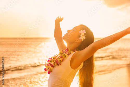 Photos Hawaii beach sunset Asian woman in sun glow sunset with arms outstretched up dan