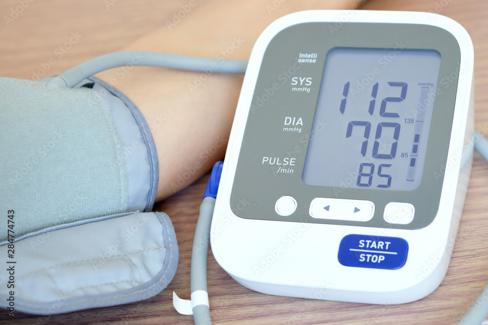Man check blood pressure monitor and heart rate monitor with digital pressure gauge. Health care and Medical concept Man check blood pressure monitor and heart rate monitor with digital pressure gauge. Health care and Medical concept