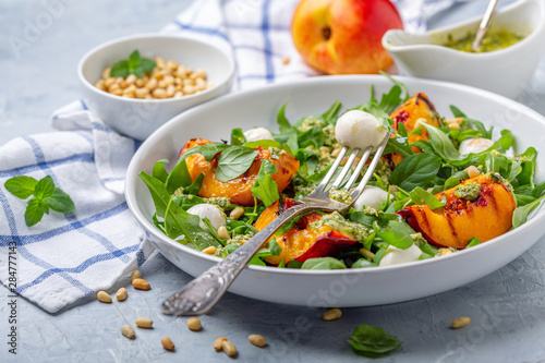 Fresh arugula salad with nectarines and pesto.