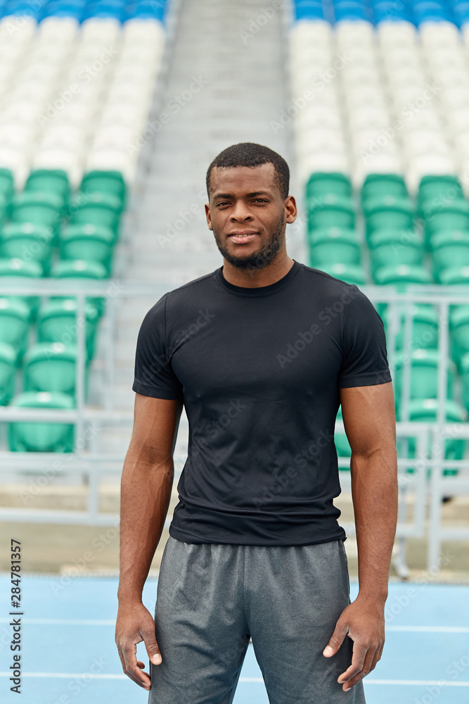 Close up photo of handsome well-built football player having a rest at the stadium. close up portrait. free time, spare time