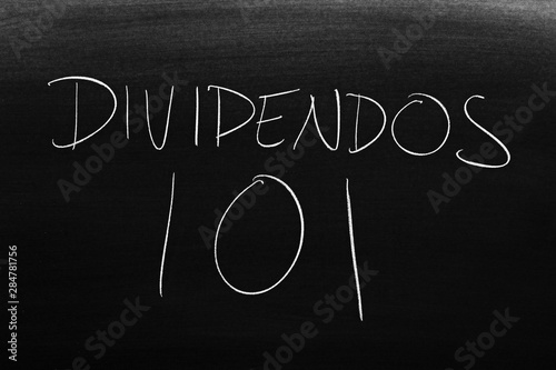 The words Dividendos 101 on a blackboard in chalk. Translation: Dividends 101