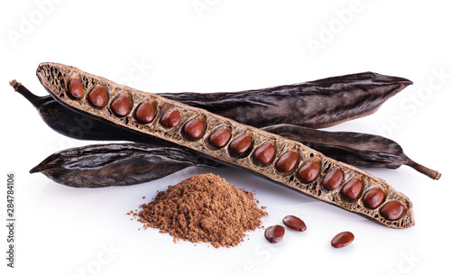 фотографія Carob pods, bean and carob powder isolated on white background.