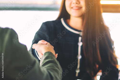Closeup image of two businesspeople shaking hands in a meeting