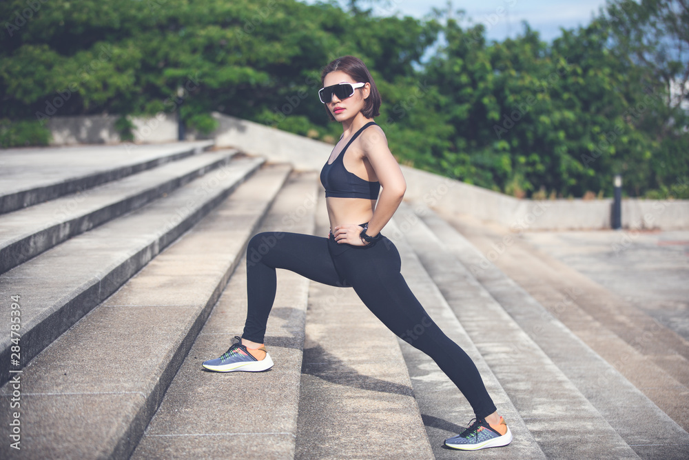Athletic woman asian warming up and Young female athlete sitting on an exercising and stretching in a park before Runner outdoors, healthy lifestyle concept Athletic woman asian warming up and Young female athlete sitting on an exercising and stretching in a park before Runner outdoors, healthy lifestyle concept