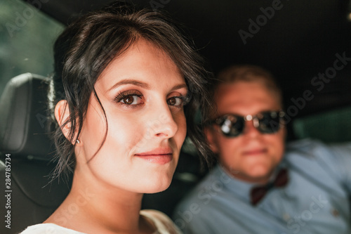 luxury elegant wedding couple holding hands in stylish black car . gorgeous bride and handsome groom in retro style. romantic moment