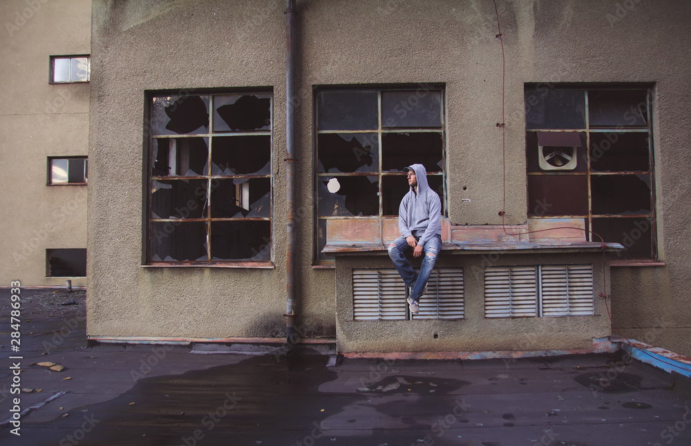 Portrait of a handsome caucasian man sitting in an old abandoned building Portrait of a handsome caucasian man sitting in an old abandoned building