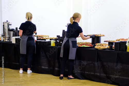 Restaurant waitress serving table with food