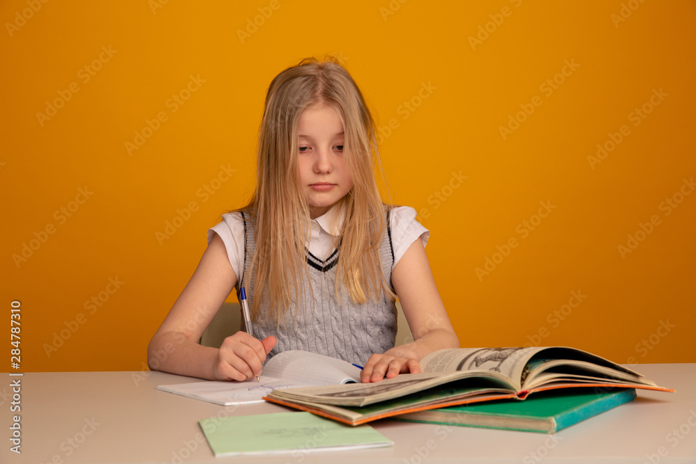 Sad and tired toddler sitting at the desk and doing homework Sad and tired toddler sitting at the desk and doing homework