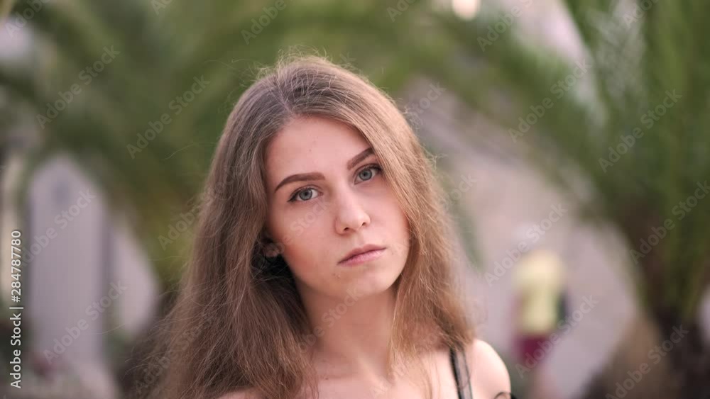 Portrait of a young attractive girl on a background of palm trees
