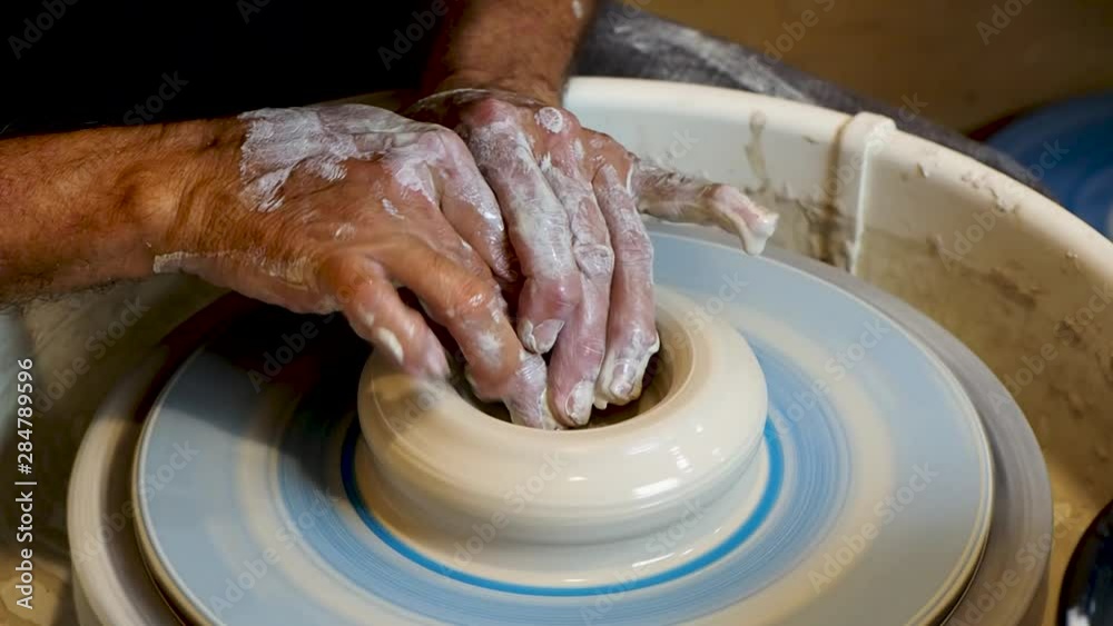 Close up of the potter's hand shaping and molding clay on a turning wheel . Close up of the potter's hand shaping and molding clay on a turning wheel .