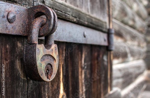 old hanging rusty iron lock on wooden door