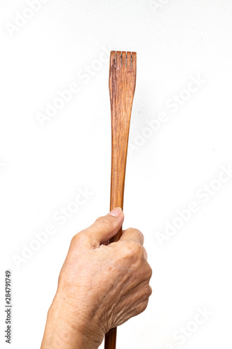 Senior woman's hand holding wood back scratcher on white background, About massage