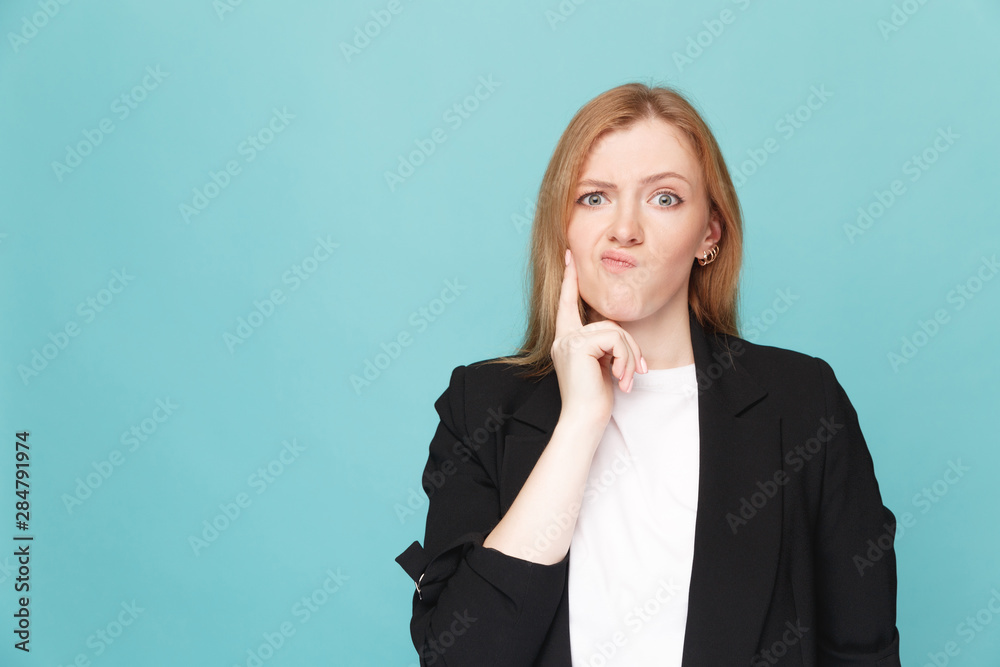 Female person standing confused in a blue studio Female person standing confused in a blue studio